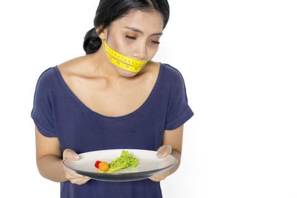 Skinny woman with salad and measure tape - Fotó, kép