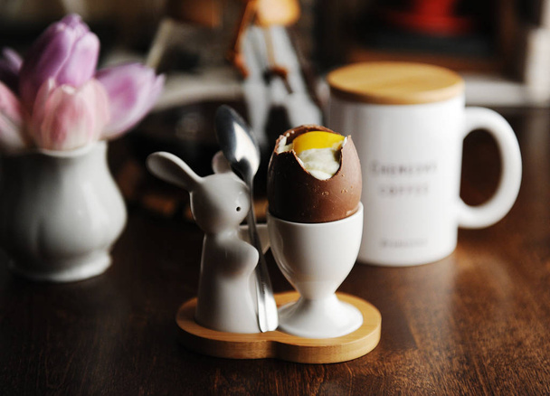 Tatlı çikolata yumurta beyaz ve sarısı taklit krema ile doldurulmuş. Paskalya tavşanı ile sahibi servis - Fotoğraf, Görsel