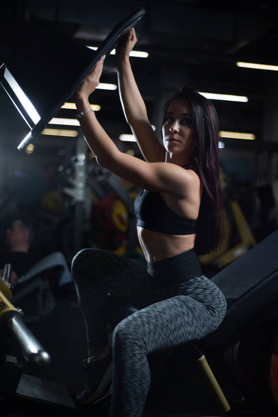 Fitness girl posing in the gym, showing off her body and relaxing after a workout - Photo, image