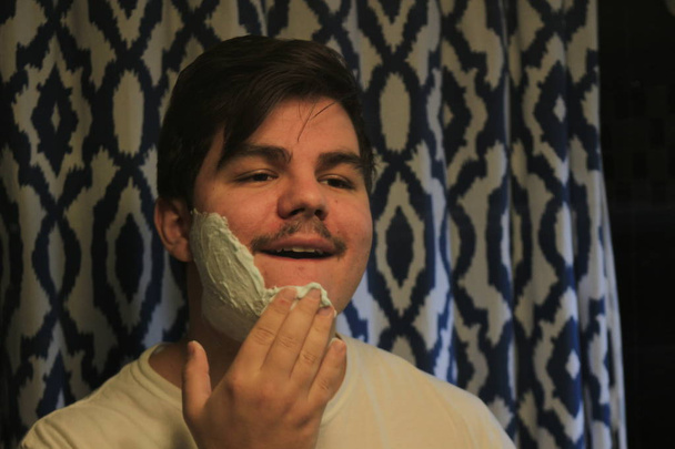 man 18 to 25 years old shaving in a mirror - Fotoğraf, Görsel