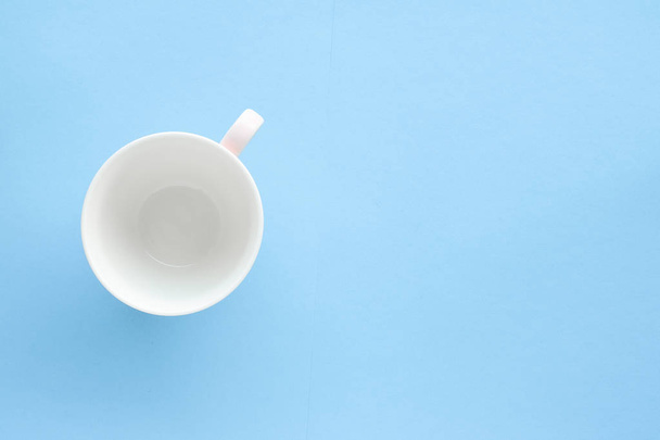 Empty cup and saucer on blue background, flatlay - Фото, изображение
