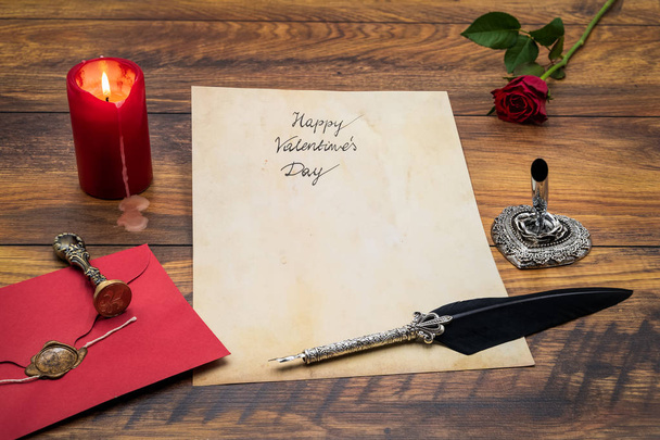 Bonne carte Saint-Valentin avec rose rouge et enveloppe, bougie et plume
 - Photo, image