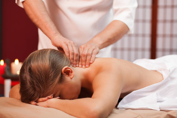 Profesjonalne spa masażysta masaż szyi kobiety klienta. Kobieta podczas całego ciała kojący masaż relaksujący. Przycięte strzał pracy terapeuty spa. Usługi świadczone przez ośrodek. Tradycje, podróży koncepcja - Zdjęcie, obraz