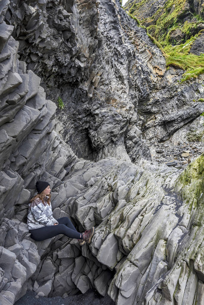 Tinédzser lány ül a bazalt sziklák, az alsó Reyni - Fotó, kép