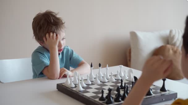 Two boy playing chess in light room. Two brothers playing chess. - Metraje, vídeo