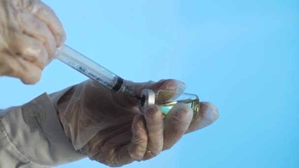 Syringe needle pierces the rubber stopper of the glass vial and filling syringe from glass - Materiaali, video