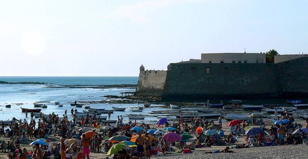 άτομα που κάνουν ηλιοθεραπεία στο ηλιοβασίλεμα στην παραλία La Caleta στον κόλπο του Κάντιθ. Ανδαλουσία. Ισπανία. Ευρώπη - Φωτογραφία, εικόνα