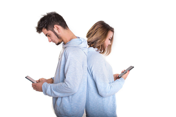 Unhappy couple backwards with their mobile phones typing isolate - Foto, afbeelding