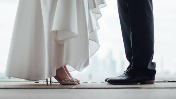 The legs of the bride and the feet of the groom - Фото, изображение