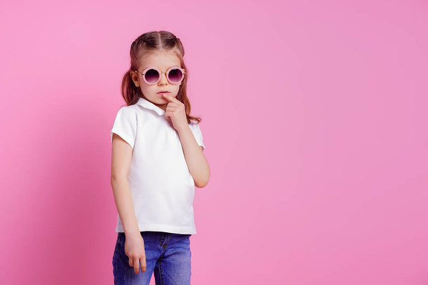 Casual 7 y.o. female in pink round sunglasses isolated on pink background - Фото, изображение
