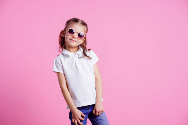 Casual 7 y.o. female in pink round sunglasses isolated on pink background - Фото, зображення