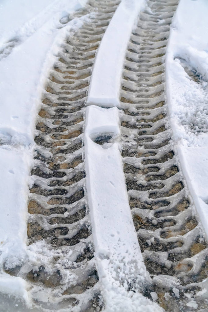 Το χιόνι κάλυψε τον δρόμο με ίχνη ελαστικών στην κοιλάδα της Γιούτα. - Φωτογραφία, εικόνα