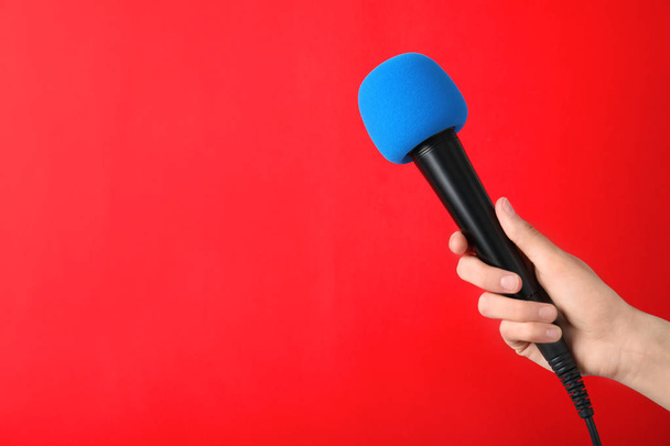 Woman holding modern microphone on color background, closeup. Space for text - Foto, Bild