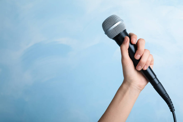 Woman holding modern microphone on color background, closeup. Space for text - Zdjęcie, obraz