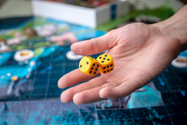 The hand throws yellow dice on the playing field. Luck and excitement. Concept Board games - Photo, Image