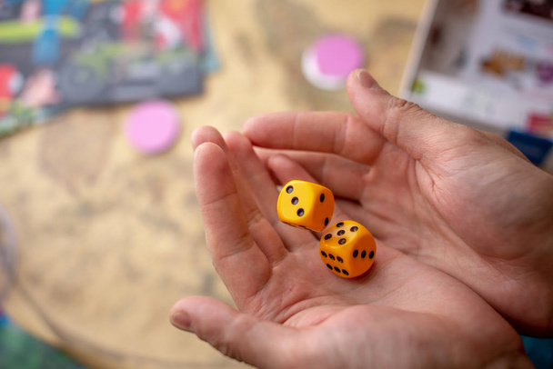 Hands throws yellow dice on the game field. Luck and excitement. Concept of Board games. Gaming moments in dynamics - Photo, Image