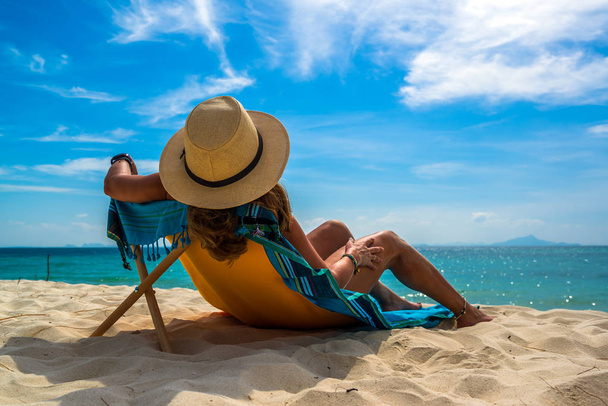 Woman enjoying her holidays on a transat at the tropical beach  - Фото, изображение