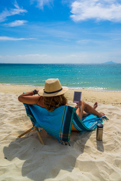 Woman enjoying her holidays on a transat at the tropical beach  - Foto, Bild