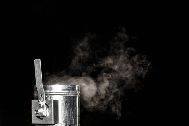 λευκό ατμού κάπνισμα από μια βαλβίδα διεξόδων σε μαύρο φόντο - Φωτογραφία, εικόνα