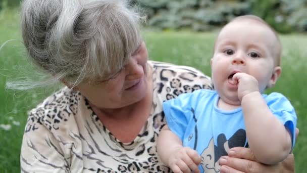 スローモーションで晴れた日に彼の grandmom の手で遊んで勇敢な子供 - 映像、動画