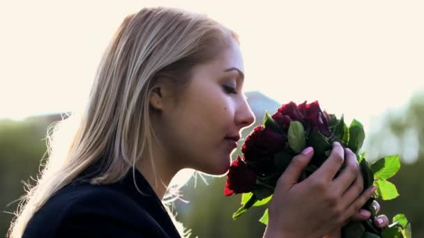 blond women smelling on red roses - Footage, Video