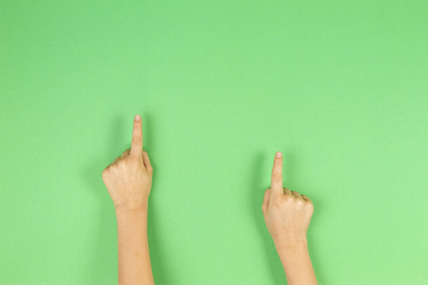 Mani di bambino dita puntate su sfondo verde chiaro
 - Foto, immagini