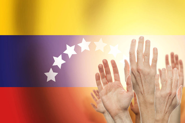 Yükselterek eller insanlar ve Venezuela arka plan üzerinde bayrak.  - Fotoğraf, Görsel