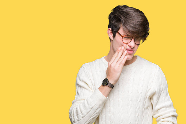Fiatal jóképű férfi szemüveg megható száj, kezével fájdalmas kifejezés, fogfájás, vagy a fogak-a Fogászati betegség miatt elszigetelt háttérhez képest. Fogorvos-koncepció. - Fotó, kép