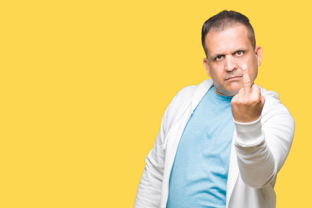 Арабський чоловік середнього віку в сорочці над ізольованим тлом Показує середній палець, неввічливий і грубий хуй вираз
 - Фото, зображення