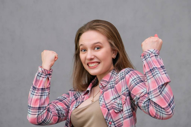 πορτρέτο του soncept χαρούμενα μακρυμάλλης μελαχρινή νεαρή γυναίκα με casual ρούχα σε στενό τζιν και ένα καρώ πουκάμισο. - Φωτογραφία, εικόνα