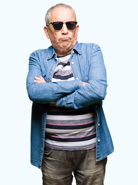 Handsome senior man wearing denim jacket and sunglasses skeptic and nervous, disapproving expression on face with crossed arms. Negative person. - Foto, Imagem
