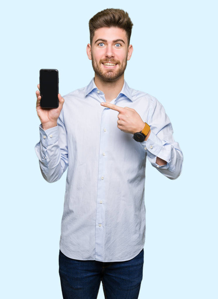 Jonge knappe man business weergegeven: smartphone scherm erg blij met de hand en de vinger te wijzen - Foto, afbeelding