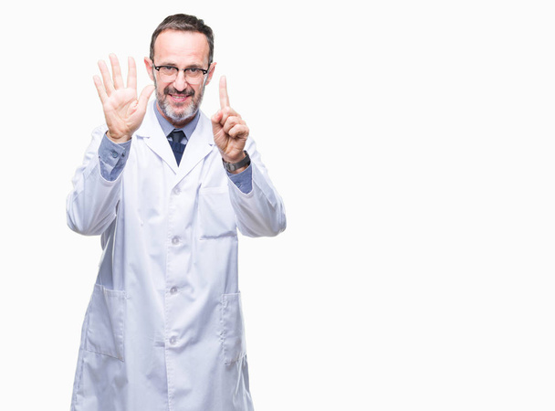 Middle age senior hoary professional man wearing white coat over isolated background showing and pointing up with fingers number six while smiling confident and happy. - Photo, Image