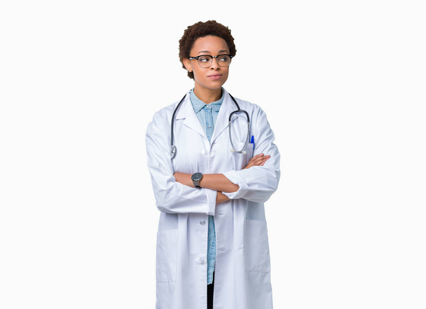 Mladý americký lékař žena nosí lékařský plášť přes izolované pozadí vypadající strana a vytřeštěné pryč myšlení. - Fotografie, Obrázek