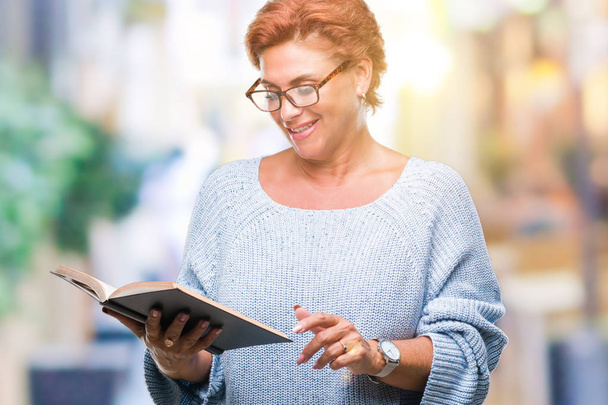 Senior valkoihoinen nainen lukee kirjaa yli eristetty tausta onnellinen kasvot pystyssä ja hymyillen luottavainen hymy osoittaa hampaat
 - Valokuva, kuva
