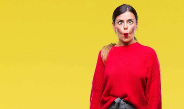Young beautiful business woman wearing winter sweater over isolated background making fish face with lips, crazy and comical gesture. Funny expression. - Photo, Image