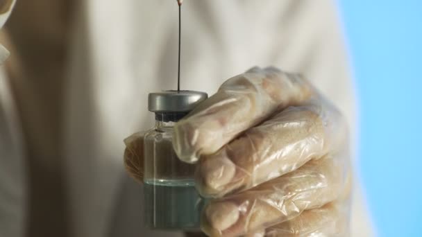 Syringe squirting a red fluid into ampoule with blue medicine. - Footage, Video