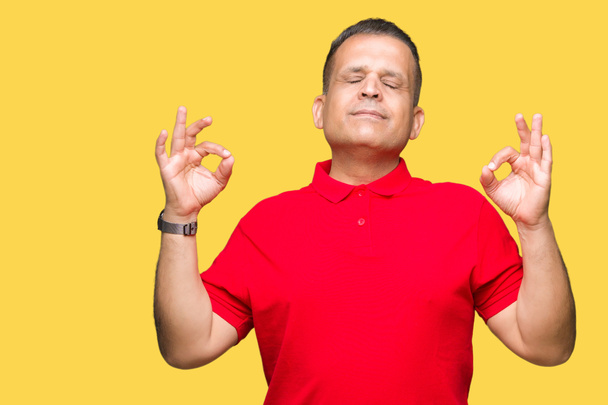 Middle age arab man over isolated background relax and smiling with eyes closed doing meditation gesture with fingers. Yoga concept. - Photo, Image