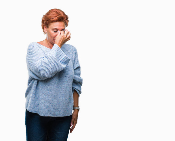Korzystna starszy rude kaukaski kobieta sobie sweter zimowy nad na białym tle zmęczony, pocieranie nosa i oczu, uczucie zmęczenia i bóle głowy. Pojęcie stresu i frustracji. - Zdjęcie, obraz