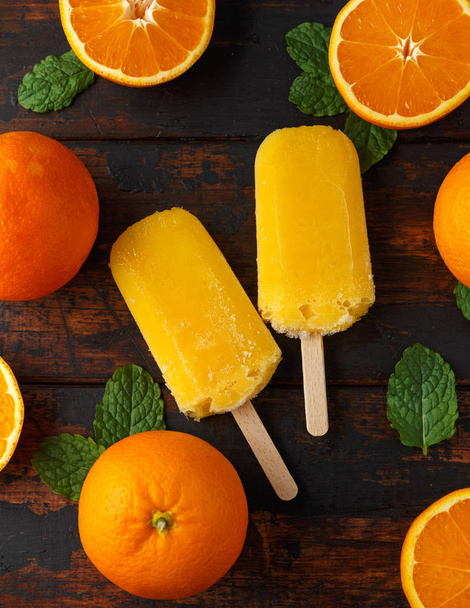 Homemade orange popsicles, ice lolly, on wooden table. Summer food. - Foto, immagini