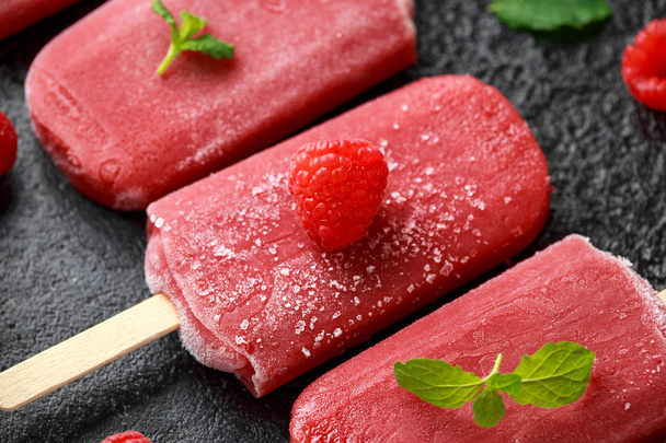 Homemade raspberry popsicles, ice lolly on rustic black background - Photo, image