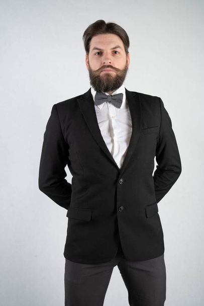 білий слуга з бородою в офіційному діловому костюмі стоїть зі сталевим підносом в руці і келихом вина на білому твердому фоні в студії
 - Фото, зображення