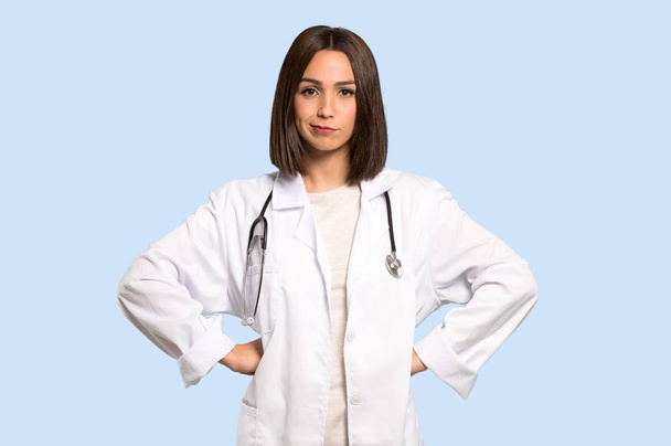 Молодая женщина врач сердится на изолированном синем фоне
 - Фото, изображение