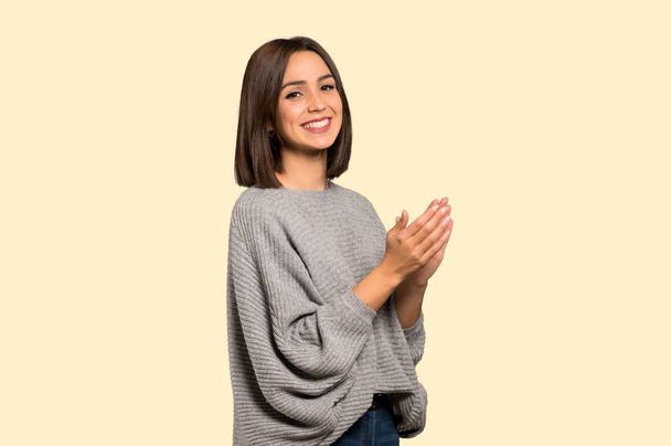 Young woman applauding after presentation in a conference on isolated yellow background - Foto, Imagen