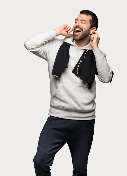 Sport man muziek met een hoofdtelefoon beluisteren over geïsoleerde grijze achtergrond - Foto, afbeelding