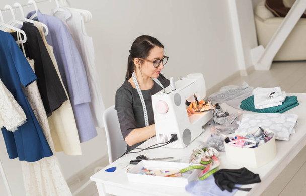 people, dressmaker, tailor, fashion and showroom concept - young fashion designer in her showroom - Zdjęcie, obraz