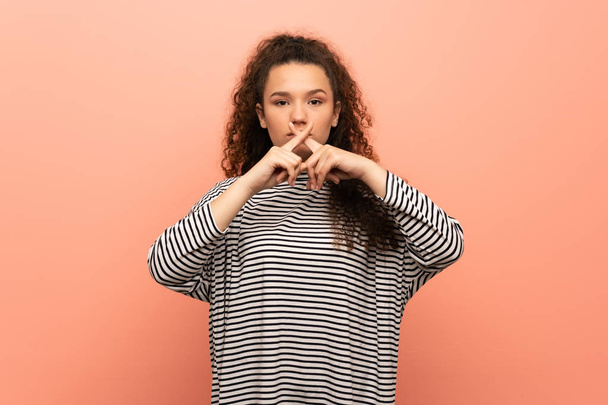 Teenager girl over pink wall showing a sign of silence gesture - Φωτογραφία, εικόνα