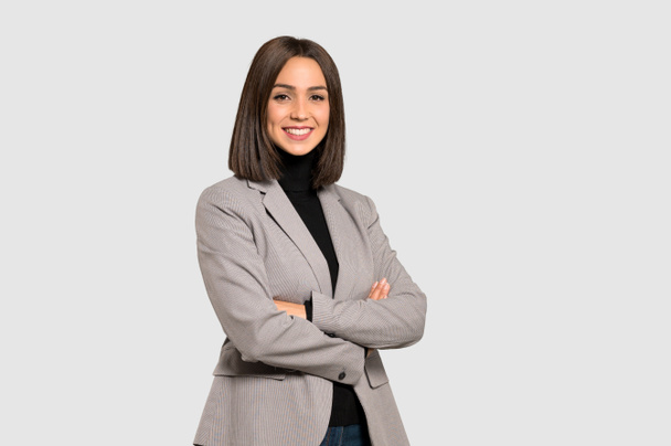 Young business woman with arms crossed and looking forward on isolated grey background - Fotografie, Obrázek