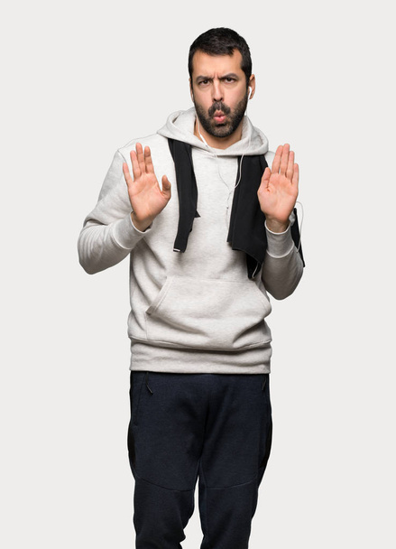 Homme sportif faisant geste d'arrêt avec les deux mains sur fond gris isolé
 - Photo, image