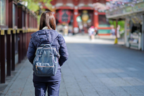 Mujer joven viajando mochilero, viajero asiático de pie en Sensoji o Asakusa Kannon Templo. hito y popular para las atracciones turísticas. concepto de viaje
 - Foto, Imagen